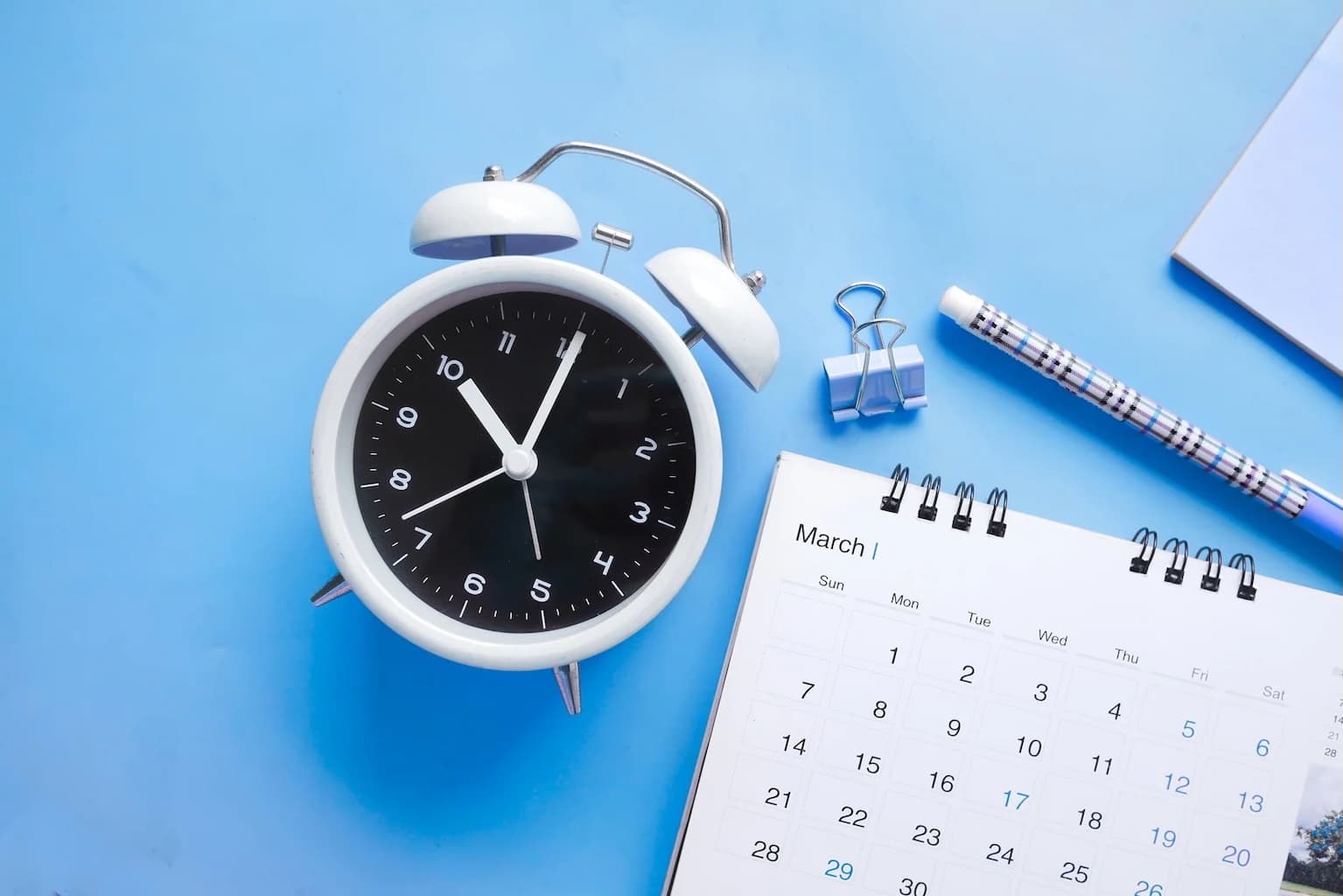 Horloge et calendrier illustrant la stratégie de contenu SEO basée sur un planning éditorial récurrent